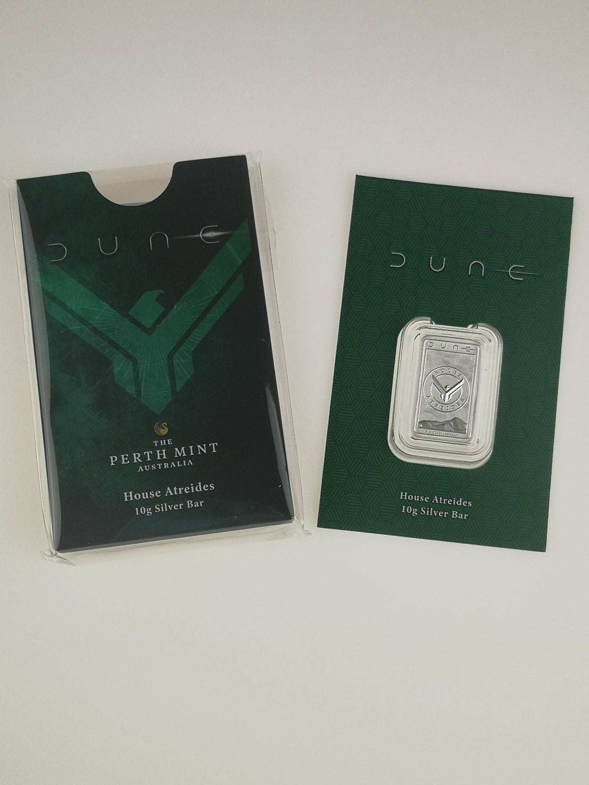 A 10g silver bar from Perth Mint Australia's 'Dune' collection, shown next to its dark green packaging card.