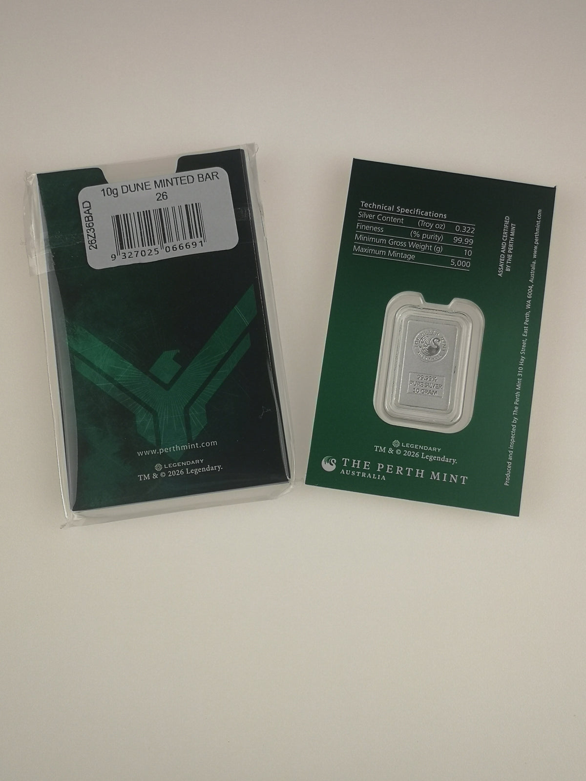 A 10g pure silver minted bar from The Perth Mint, shown with its original dark green packaging box on the left and the back of the display card on the right, set against a plain off-white background.