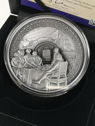 A round silver commemorative coin in a clear protective capsule, displayed inside a black presentation box. The coin features raised relief details of the Constitutional Convention.