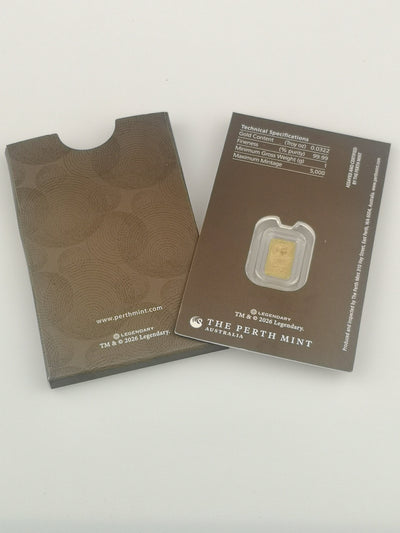 A Dune 1g gold bar from The Perth Mint in its original packaging, showing the textured brown envelope cover on the left and the technical specification card on the right.