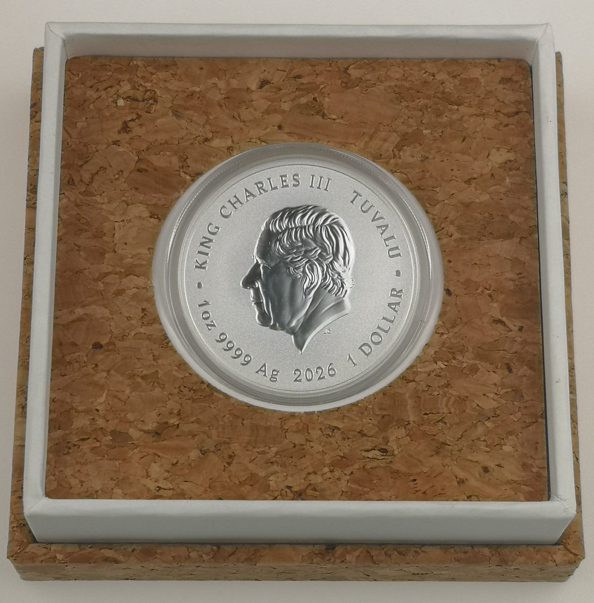 A 1oz silver Dune coin featuring a profile portrait of Charles III, displayed inside a square presentation box with a cork insert and white border.