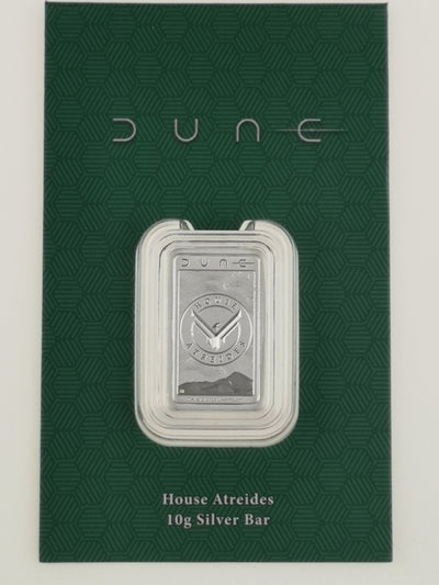 A 10g silver bar from the movie Dune, displayed in a clear protective capsule on a textured dark green backing card with the word 'dune' printed at the top.